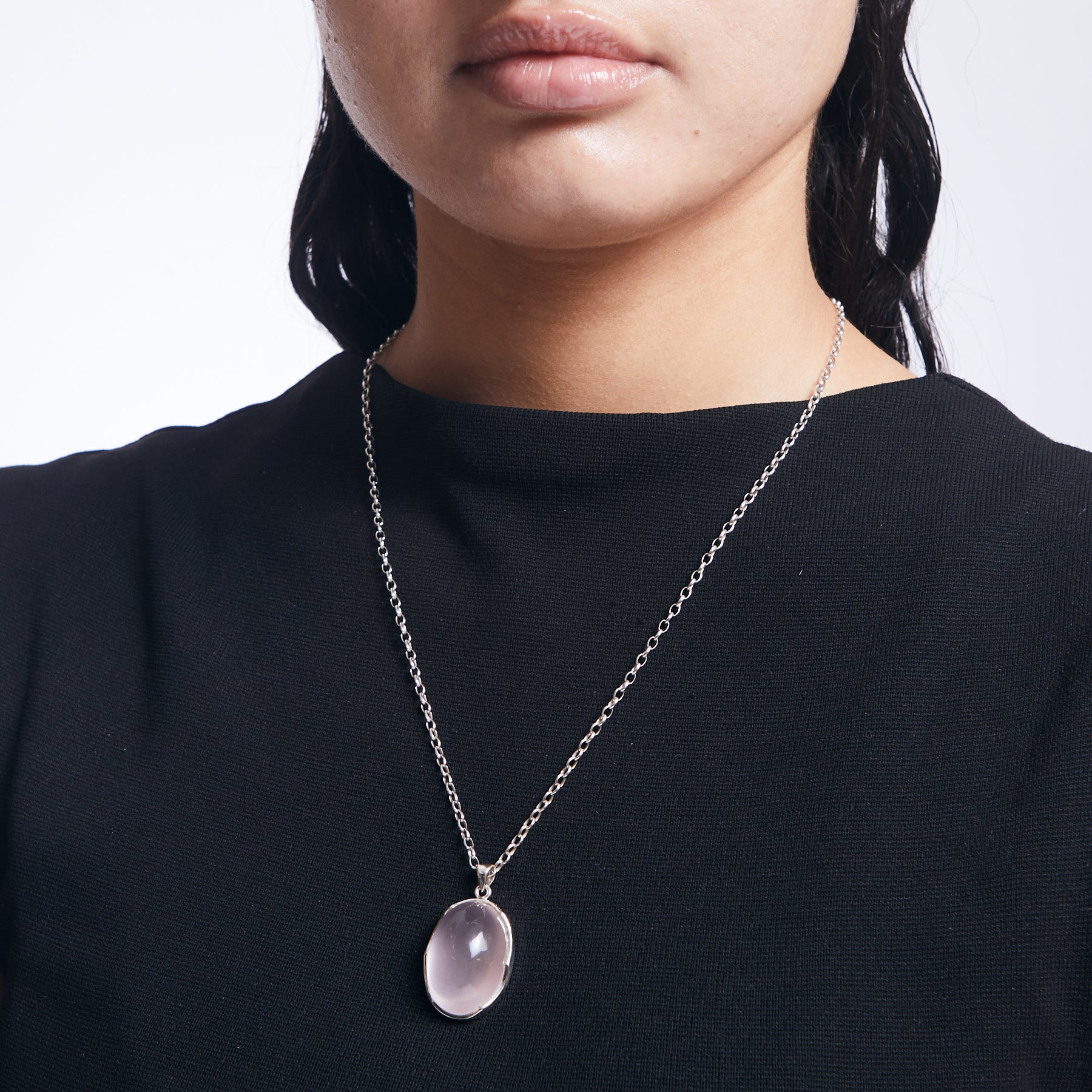 Rose Quartz oval pendant with wave bezel on sterling silver chain on model