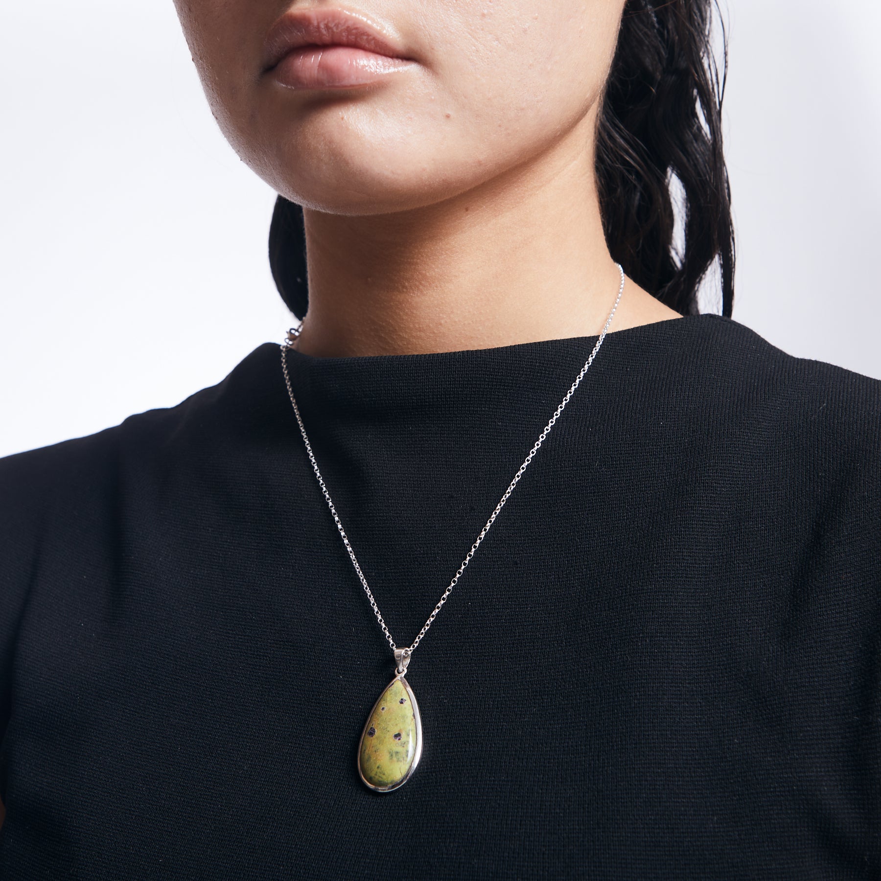 Serpentine Stitchtite teardrop pendant with on sterling silver chain on model