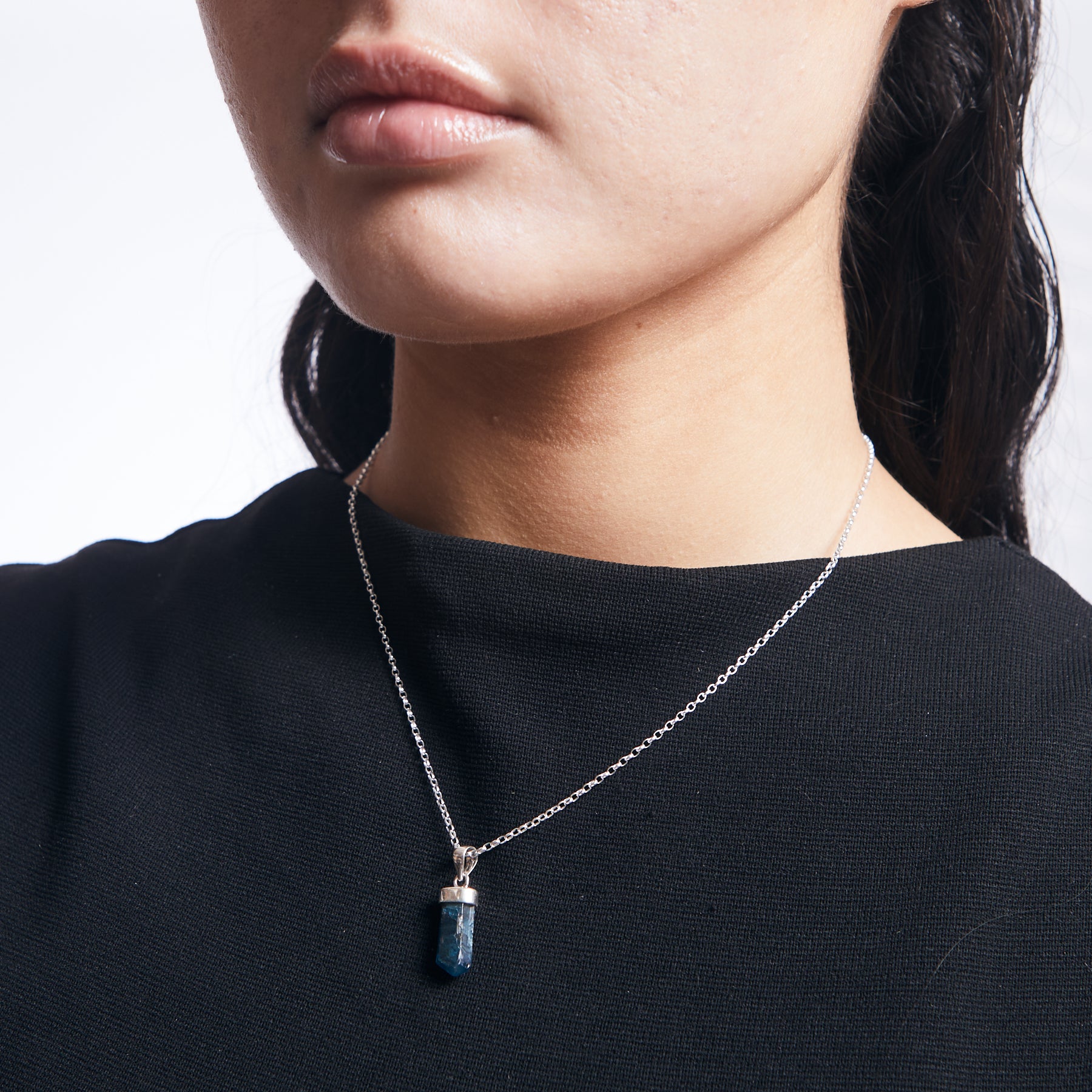 Apatite pencil pendant with bezel cap on sterling silver chain on model