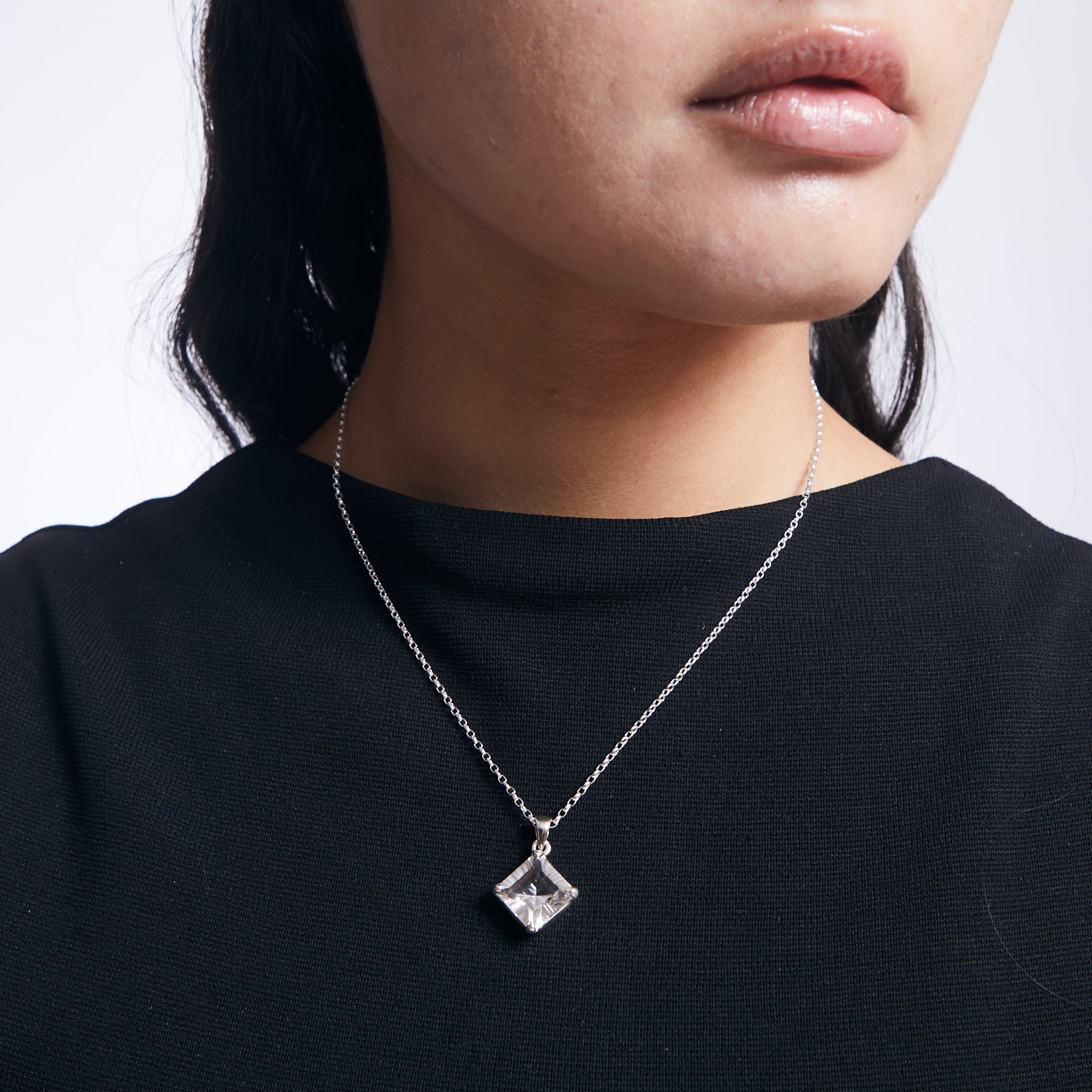 Clear Quartz diamond shaped faceted pendant with sterling silver chain on model