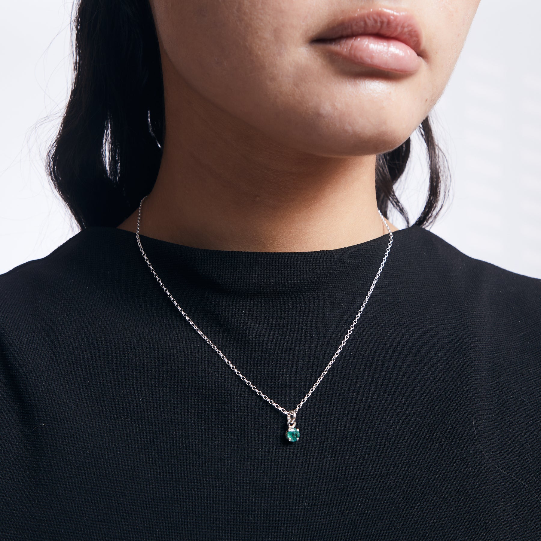 Emerald faceted round pendant with sterling silver chain on model