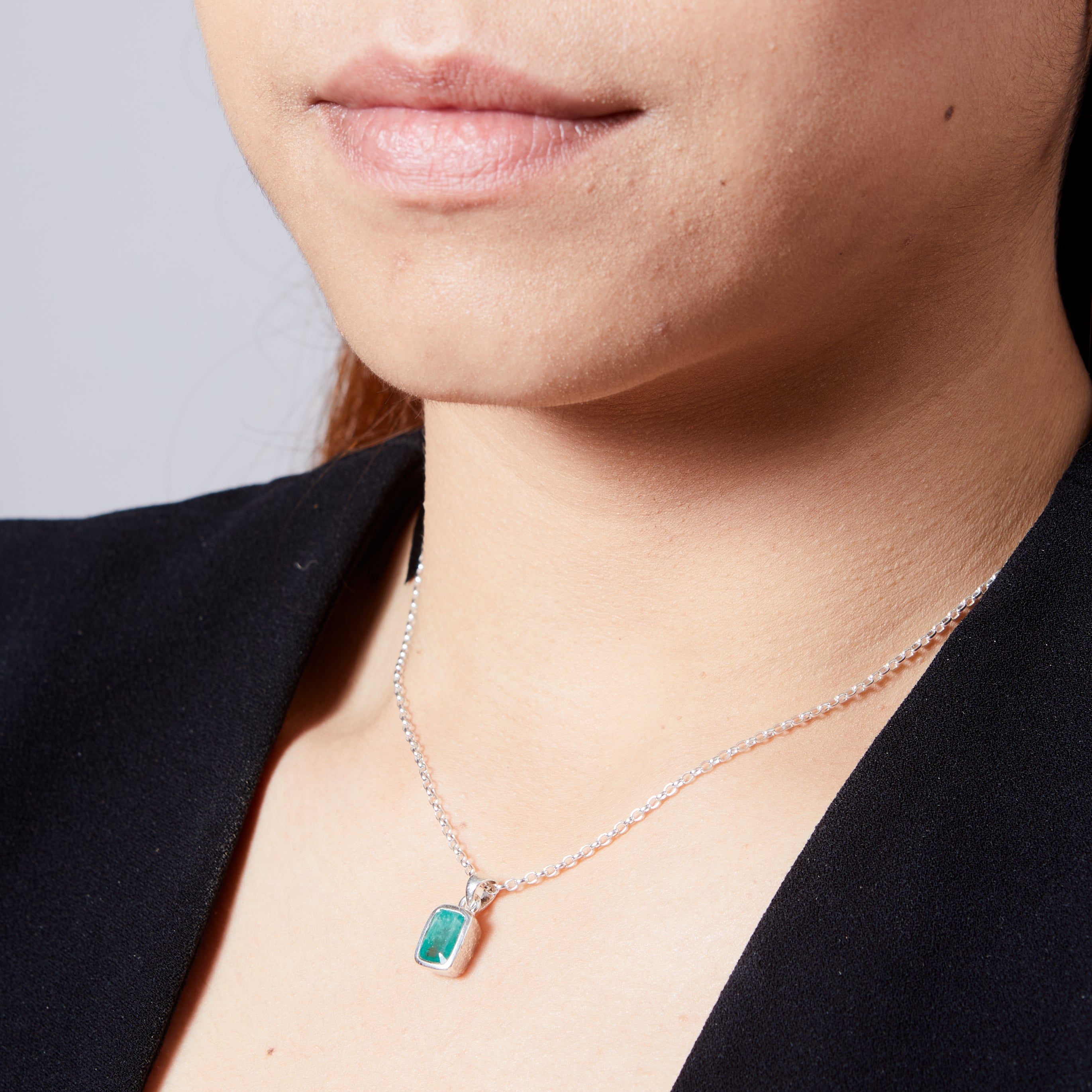 Emerald faceted rectangle hammered bezel set pendant on model