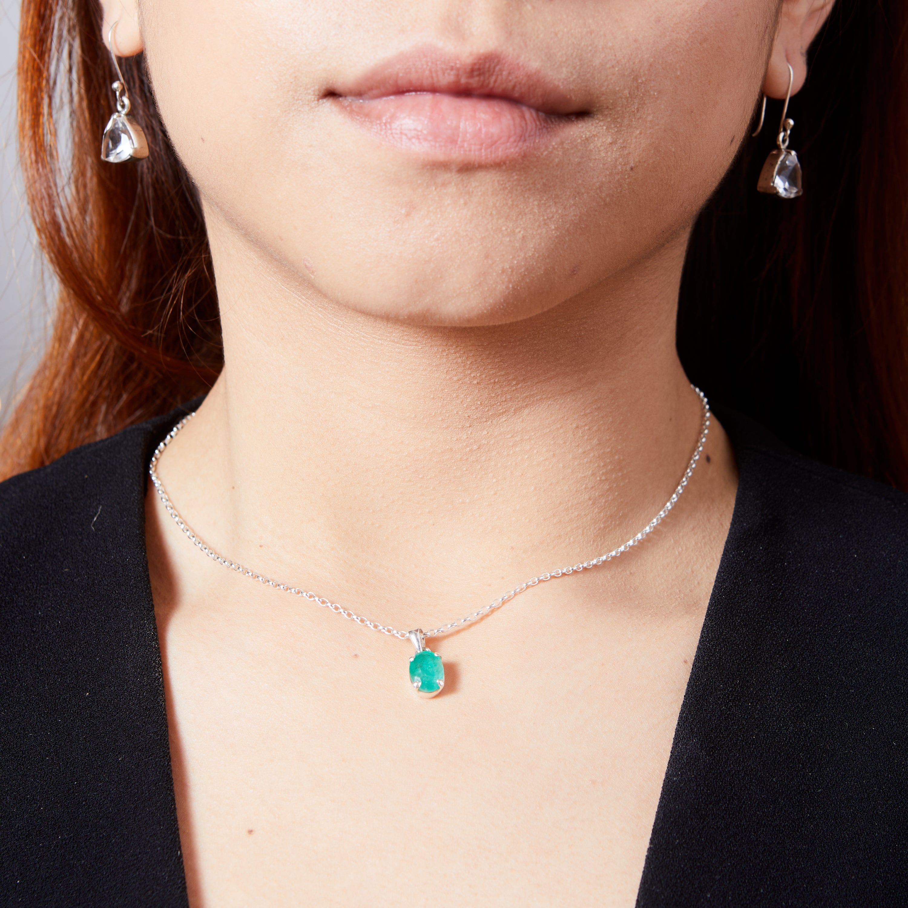 Emerald faceted oval claw set pendant on model 