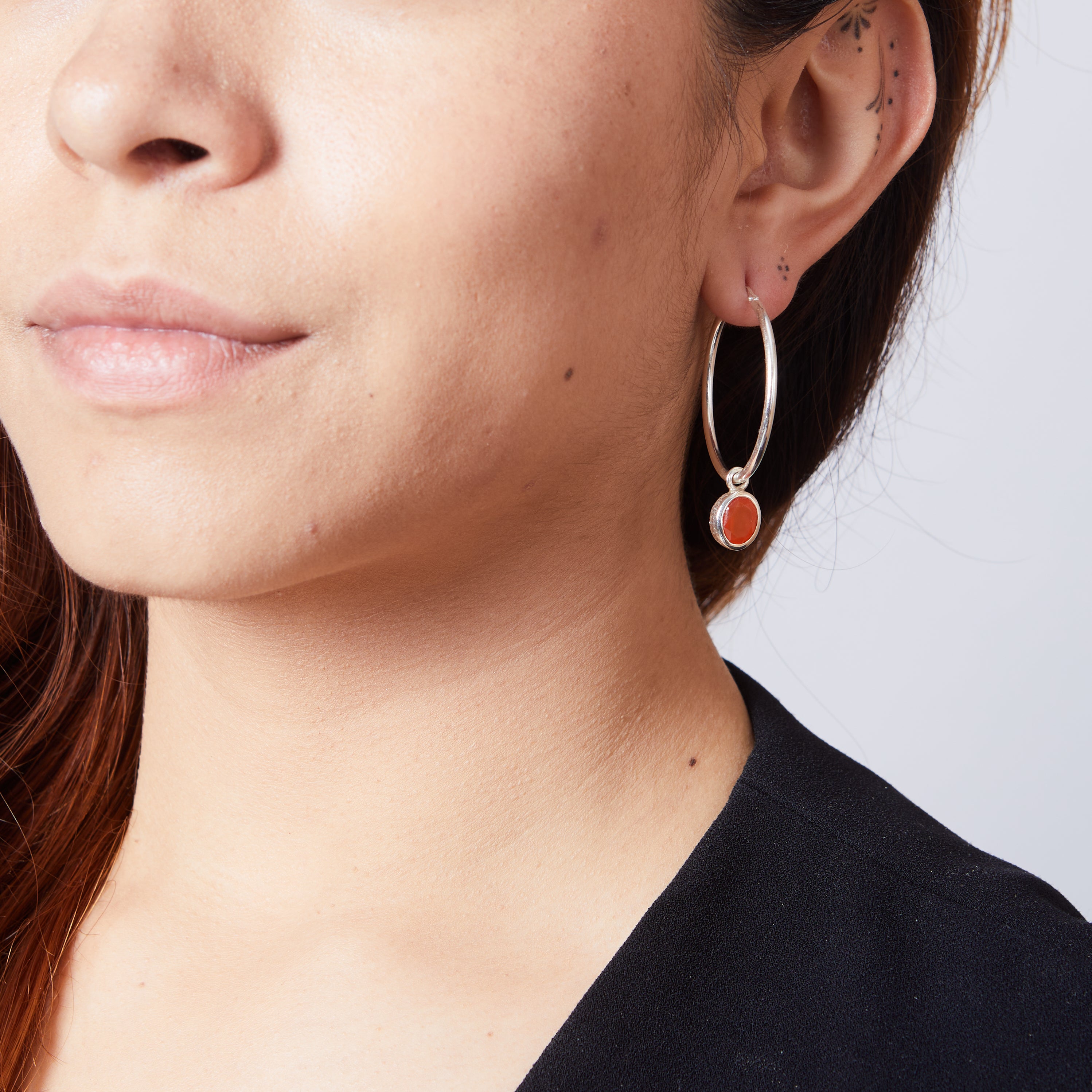 Carnelian faceted oval hammered bezel set hoop attachments on model