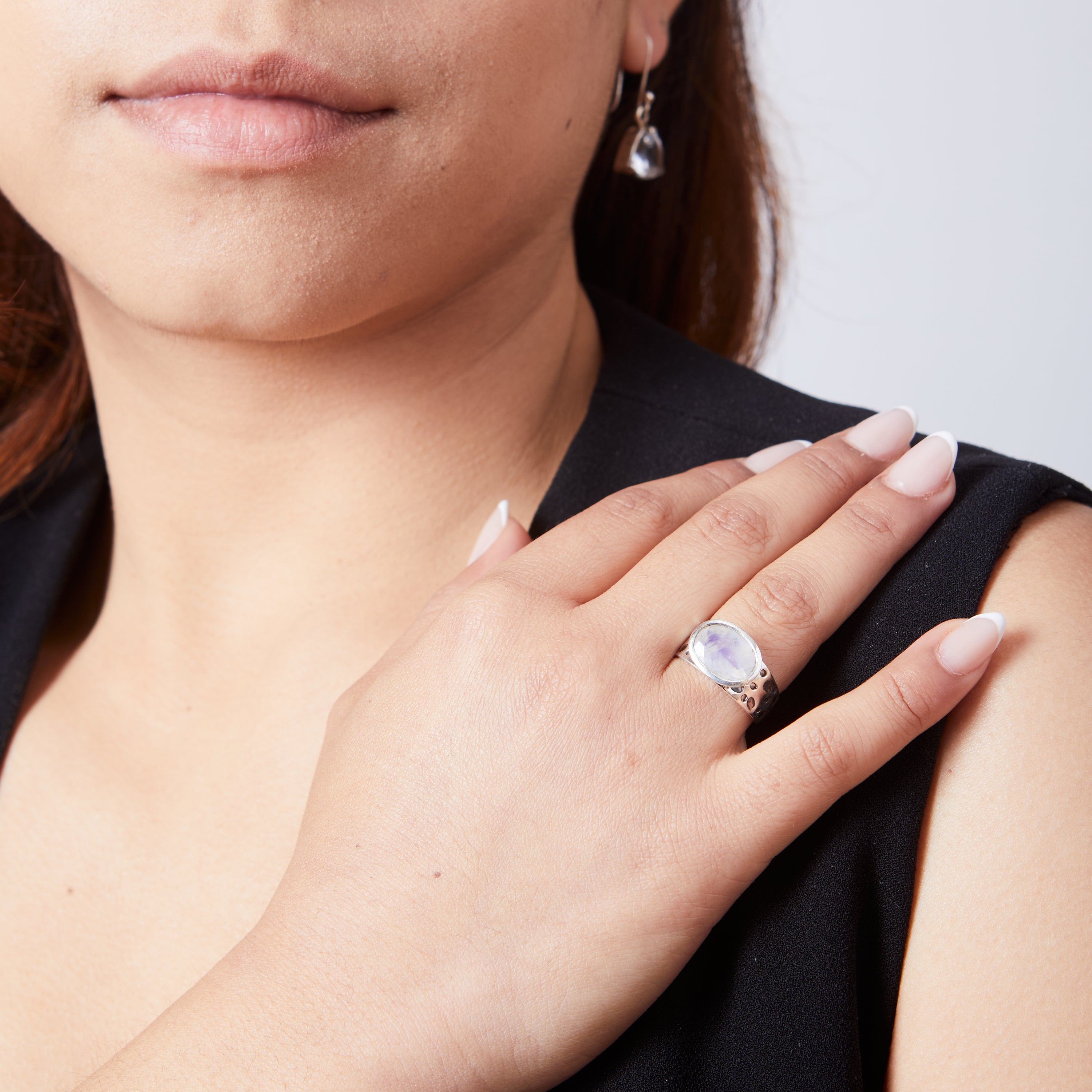 Rainbow Moonstone oval faceted bezel set ring with dot textured band on model