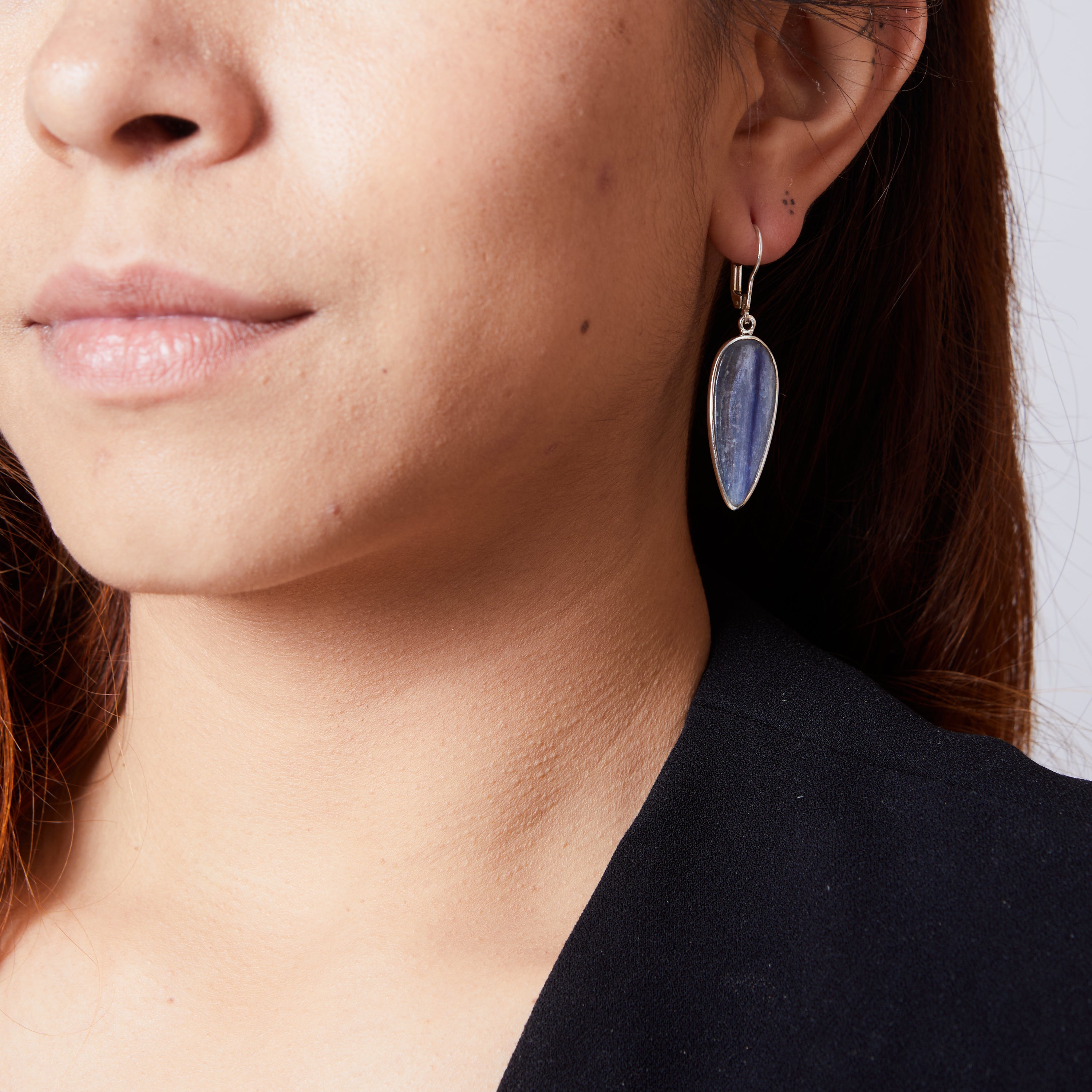 Blue Kyanite inverted teardrop clasp earrings with bezel setting on model