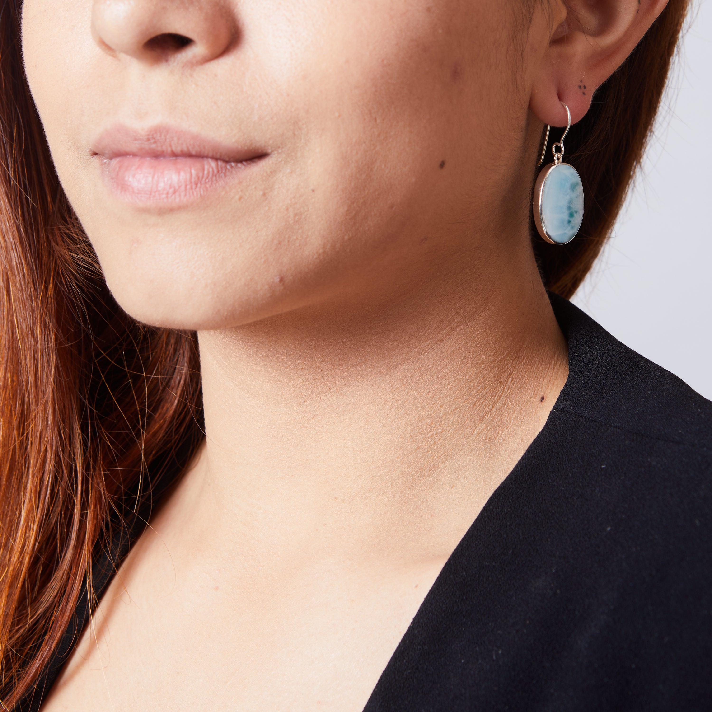 Larimar oval cabochon bezel set drop earrings on model