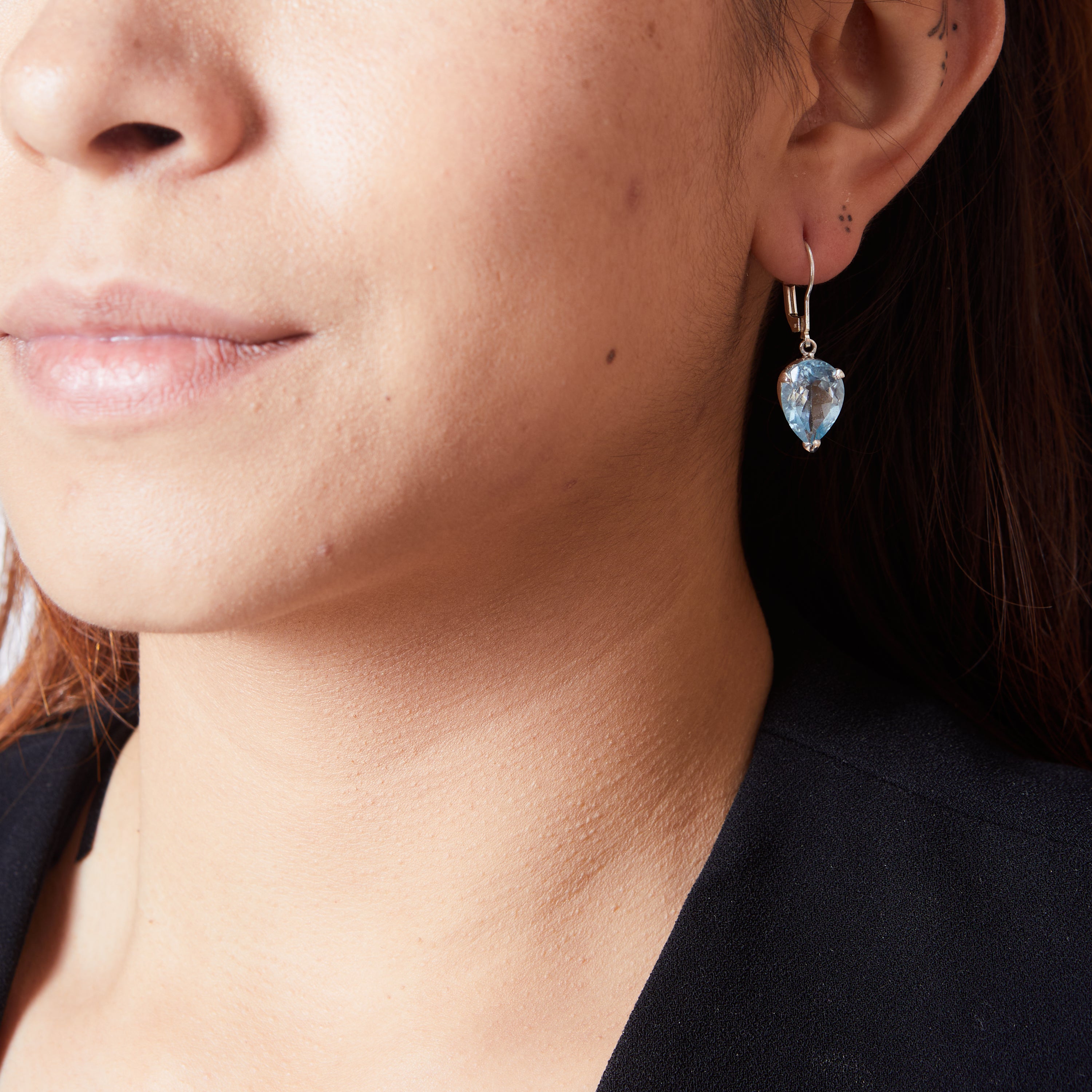 Blue Topaz faceted inverted teardrop claw set clasp drop earrings on model