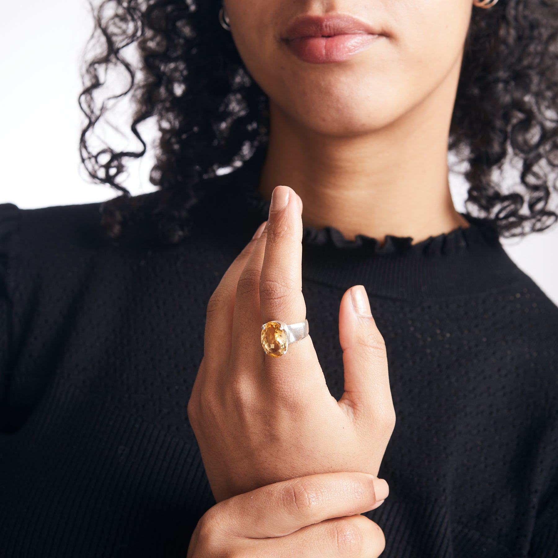 Citrine oval laser cut facet with sterling silver claw bezel on thick band on model