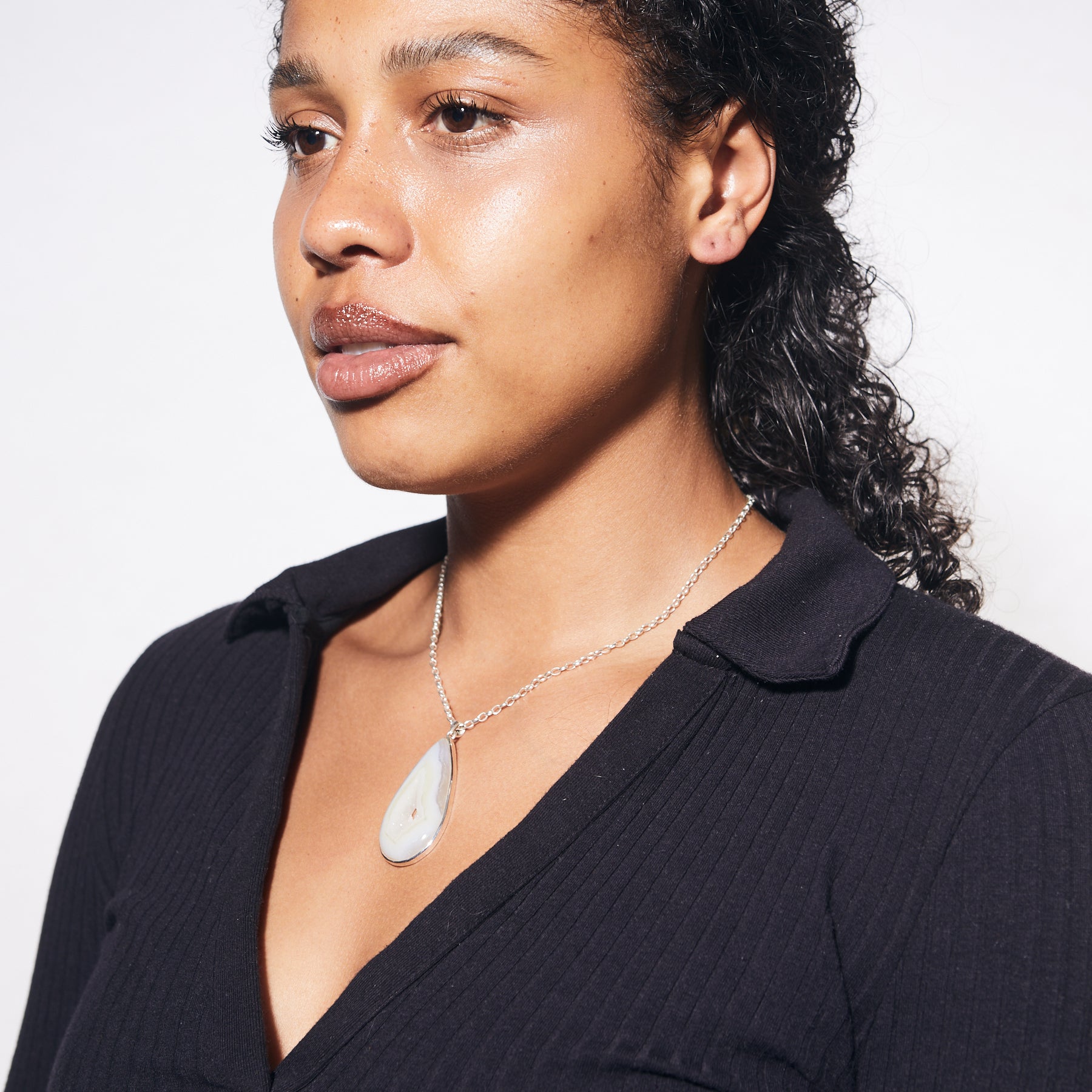 Agate teardrop druzy bezel set pendant on model